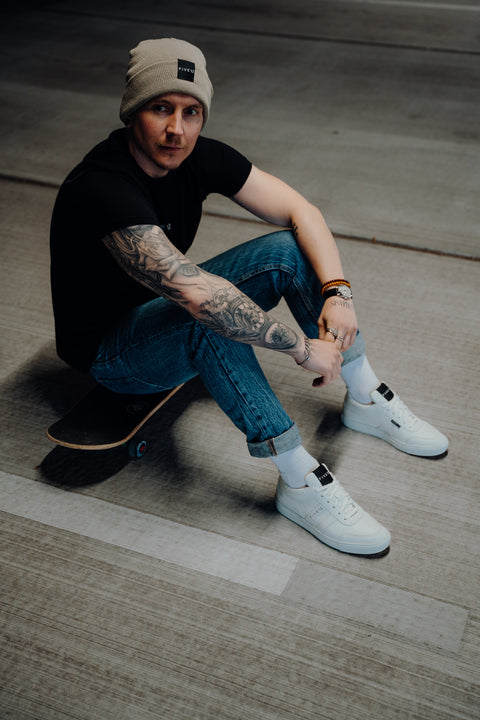 Mann mit Mütze, Sneaker weiß mit Mann, Männerschuhe, Schwarzes T-shirt, Jeans, Model